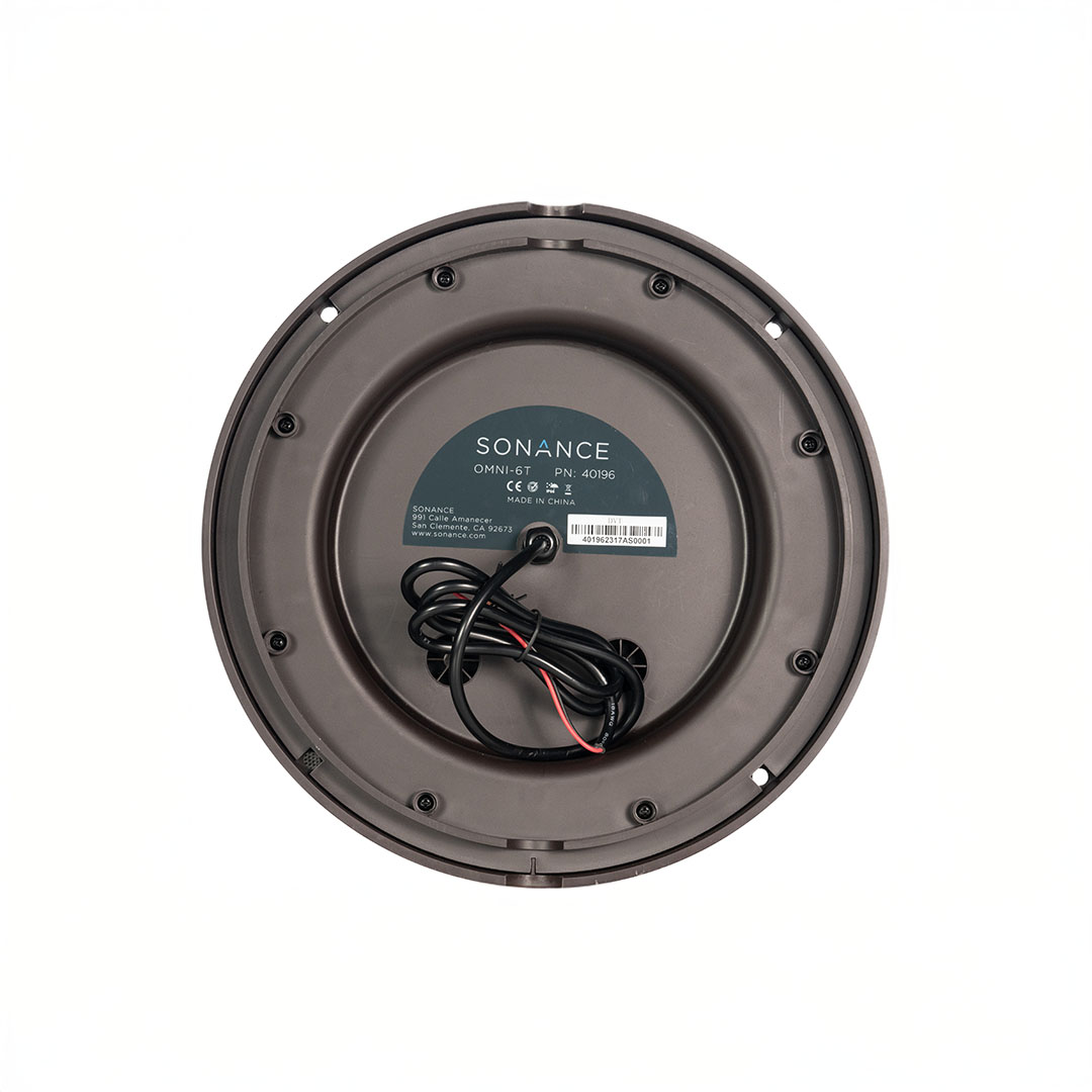 Bottom view of a circular speaker with wires.