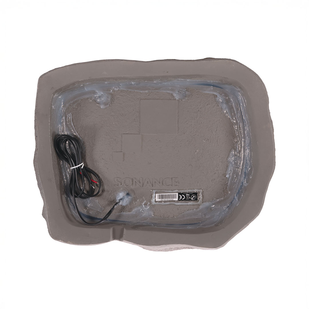 Back view of a Sonance rock speaker with wiring.