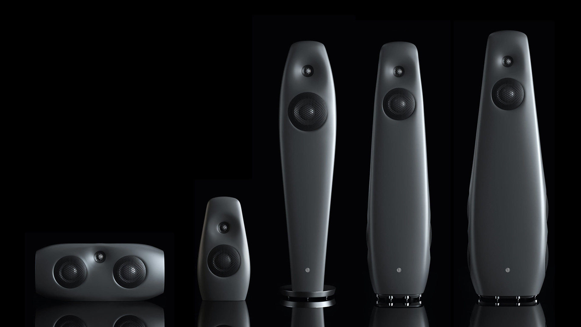 Five sleek modern black Vivid Audio speakers on display in black environment